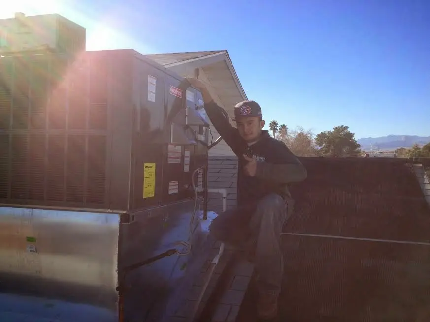 HVAC technician performing Air Duct Cleaning on a rooftop unit in Forest Grove